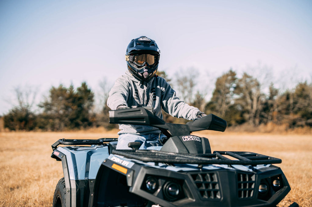Riding a Hisun ATV in a grass field