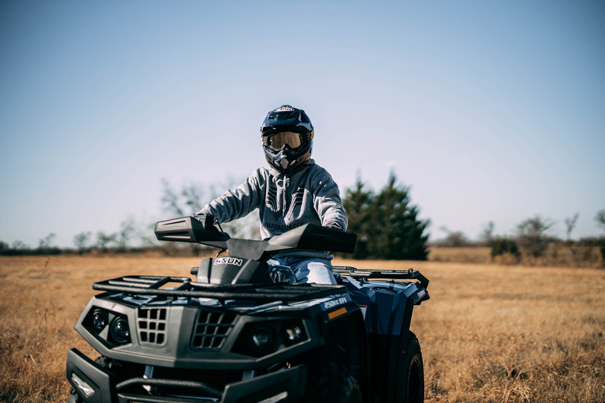 Riding a Hisun ATV in a grass field