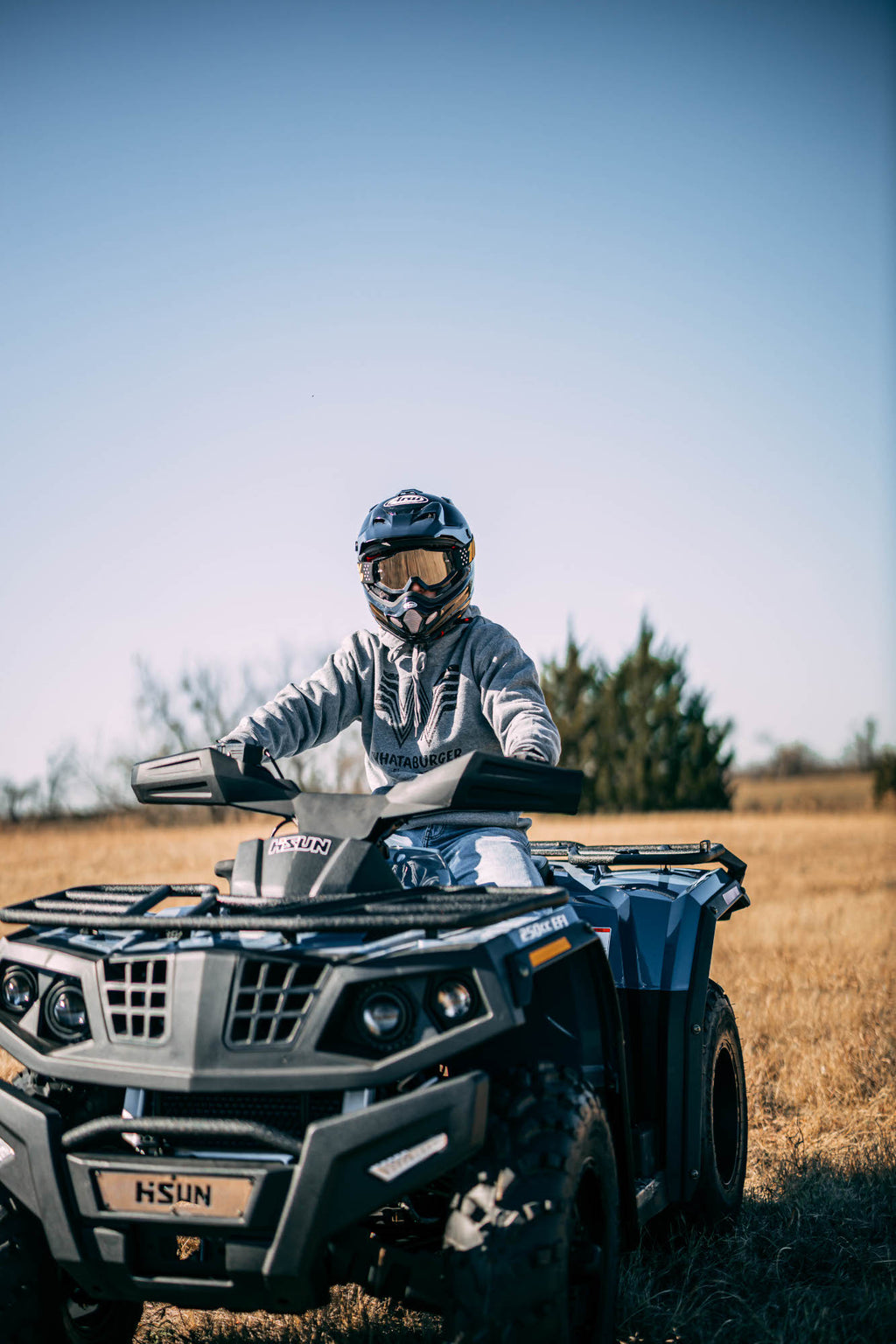 Riding a Hisun ATV in a grass field