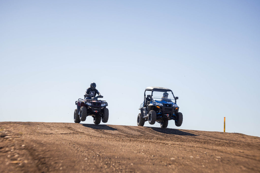 Hisun Powersports jumping a dirt hill